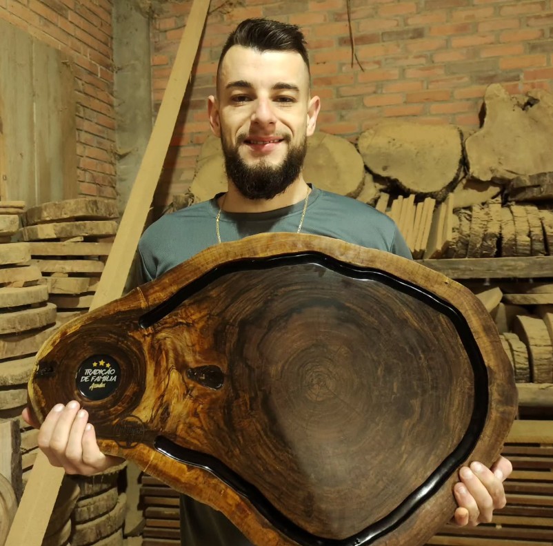 Artesão da Tábuas Curtinaz segurando uma tábua artesanal premium em madeira nobre
